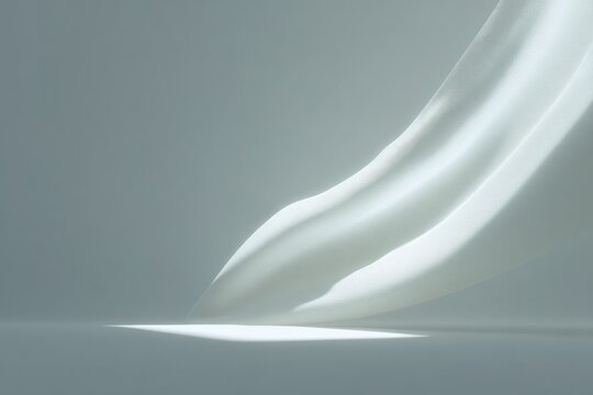 A white liquid likely milk on a gray background. the liquid appears to be a creamy white color and the background is a solid gray color.
