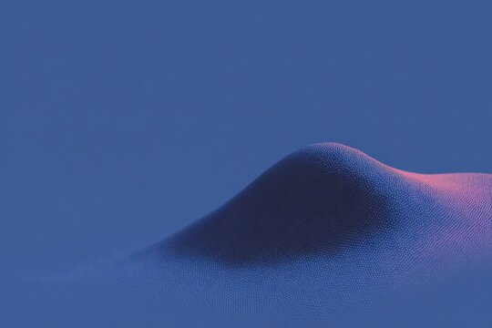 A sand dune in the desert with a blue sky in the background. the sand is a deep blue color and the sky is a bright clear blue.