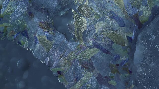 Microscopic time lapse of cross polarized light crystallization displaying metallic luster mineral structures with silver and bronze optical illusion expanding over fluid solution background