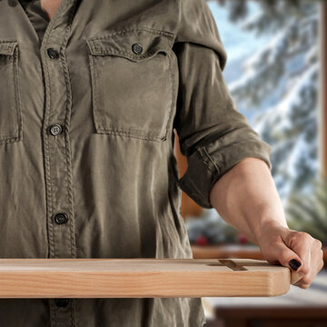 Woman holding wooden tray with copy space &ndash; cozy winter interior concept.