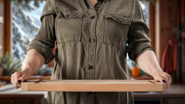 Woman holding wooden tray with copy space &ndash; cozy winter interior concept.