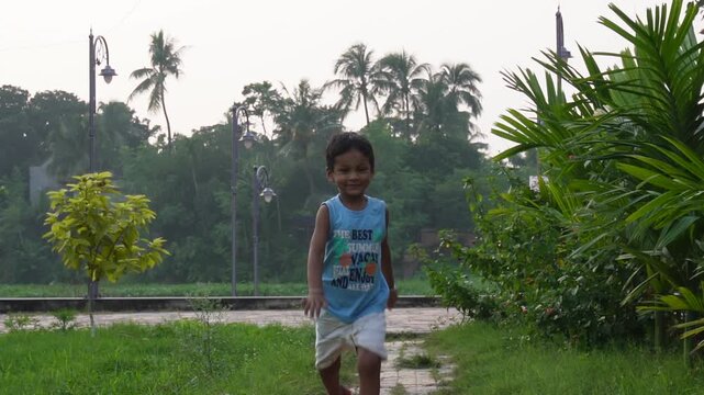 Child running outdoors near palm trees and grass