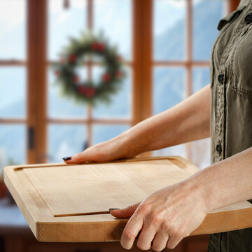 Woman holding wooden tray with copy space &ndash; cozy winter interior concept.