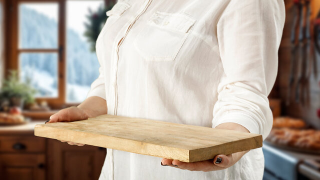 Woman holding wooden tray with copy space &ndash; cozy winter interior concept.