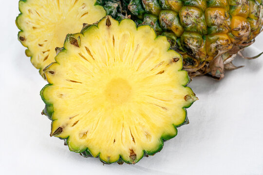 Pineapple cross section showing golden flesh and textured green rind