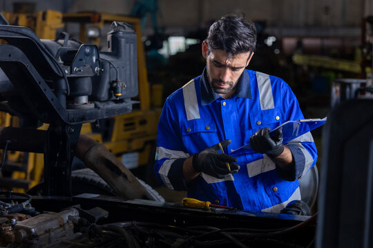 Caucasian mechanic is inspecting the diesel truck engine after annual check up in the professional garage and maintenance all the filter and gear for safety driving concept