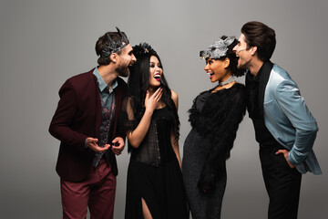 Obraz premium Group of cheerful multicultural friends celebrating Halloween with fun costumes