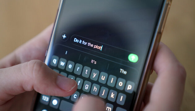 hands typing a message 'Do it for the plot!' on a smartphone, internet communication, messaging, gen z modern slang
