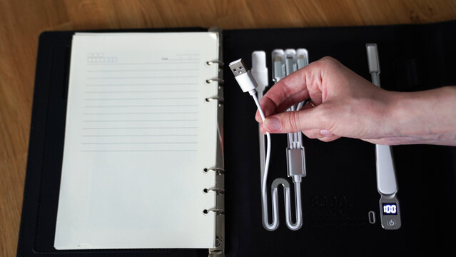 smart notebook with different types of cables on the backside, portable charging station in a notebook