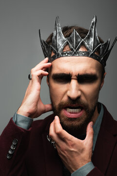 Handsome man embodying an evil king in Halloween costume and makeup