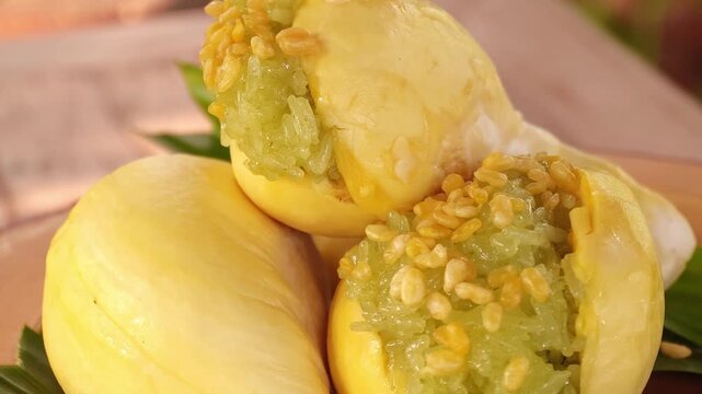 Durian with sweet sticky rice and coconut milk, a Thai dessert on a plate.