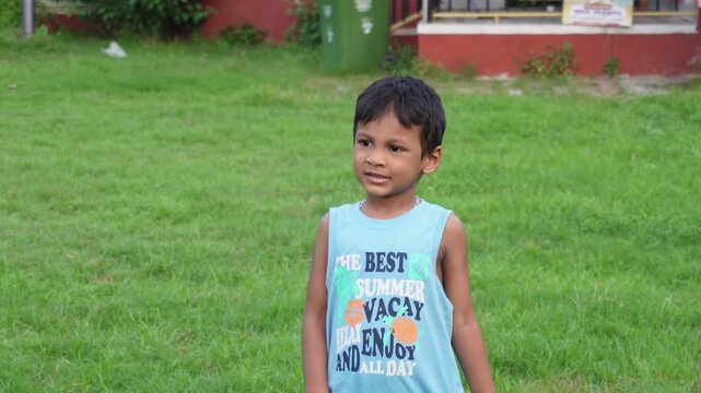 Young boy smiling outdoors on a green lawn
