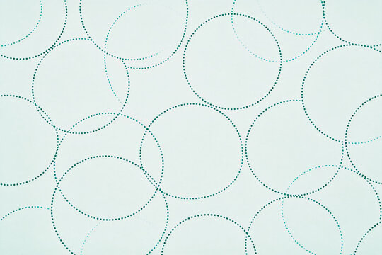 Seamless geometric pattern of dotted circles on a pale light mint background, minimalist flat design.