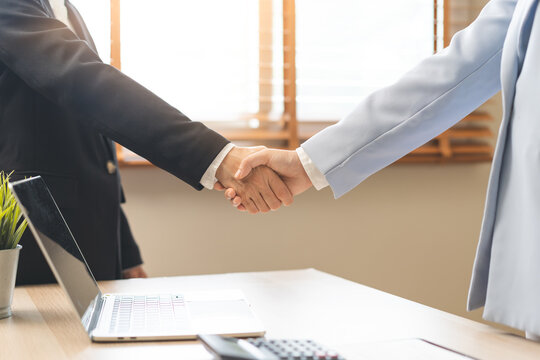 Successful deal asian young business woman, partnership, teamwork handshake or greeting together at office after project done, good deal. Happy business people, group meeting, colleagues shaking hands
