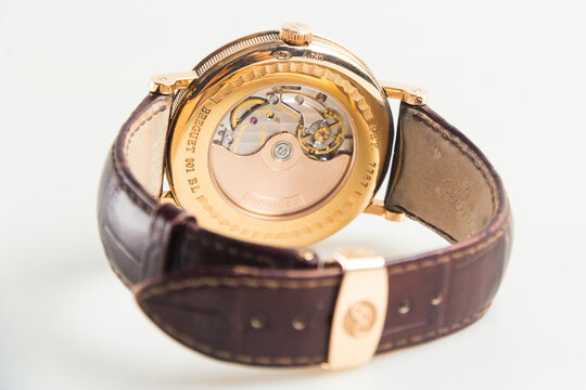 Luxury Breguet Classique wristwatch featuring a rose gold case, silver guilloch&eacute; dial, moonphase indicator, power reserve, and leather strap.