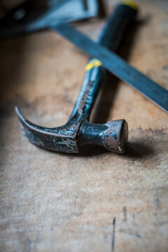 View of a metal hammer and a ruler resting on a worn wooden workbench in Looe, Cornwall, United Kingdom.