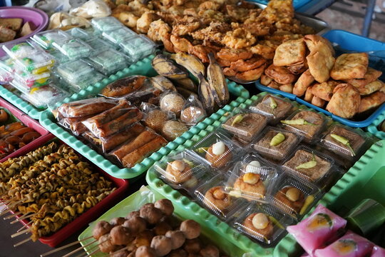 Variety of traditional Indonesian street food snacks and fried dishes displayed on trays at an angkringan stall in Java, featuring quail egg skewers, tofu, tempeh, and authentic local delicacies.food,