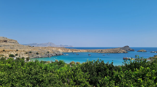Turquoise Mediterranean-Style Bay with Boats and Citrus Trees