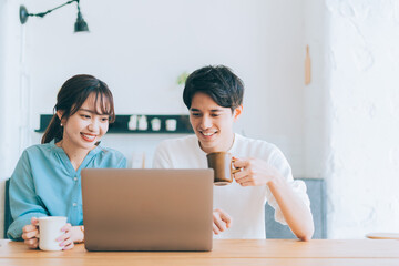Obraz premium 一緒にパソコンを見る若い夫婦