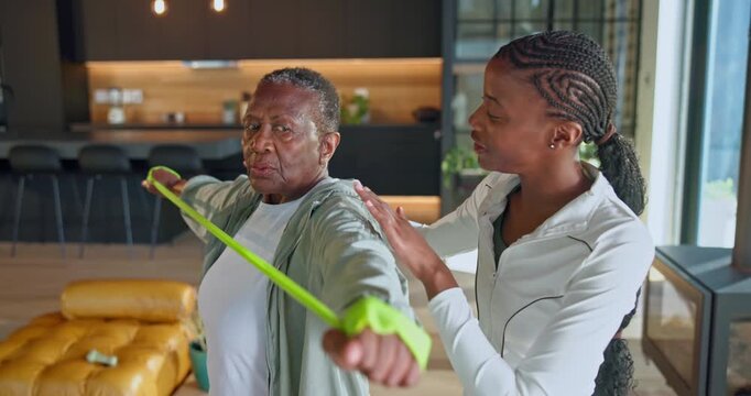 Old woman, stretching and physio at house with band, mobility and muscle strength for recovery. Physiotherapist, help and senior black person with elastic, physiotherapy and rehabilitation guidance