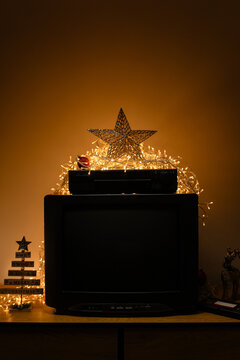 Vintage CRT TV with VCR, fairy lights and Christmas decor, featuring a blank dark screen for mockup use, retro media themes and holiday nostalgia