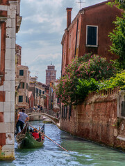 Traditional venetian gondola navigating a narrow water canal © Majul PavL