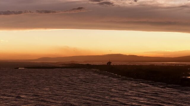 Golden sunset over Carnon coast tower silhouette and hills