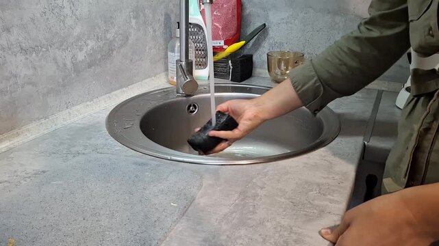 Washing black object in sink using running water