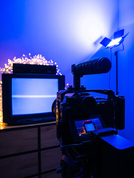 Behind the scenes of video production with mirrorless camera, studio lights and retro television setup for content creation