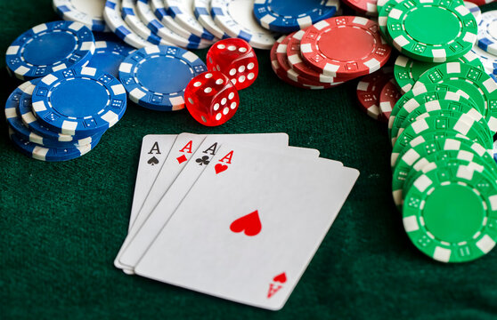poker chips stack with two cards an ACE. On the green table on a black, dark background.