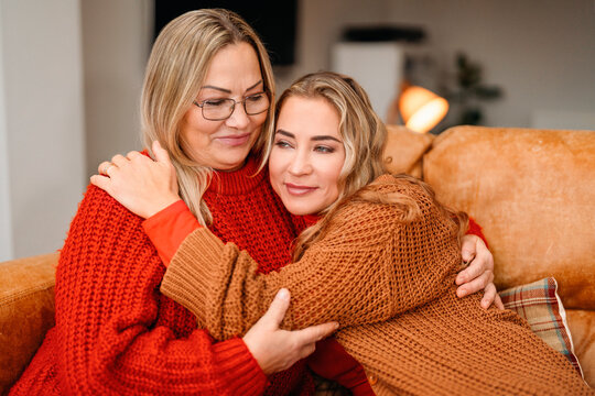 Mother and daughter share a warm hug while sitting together on a