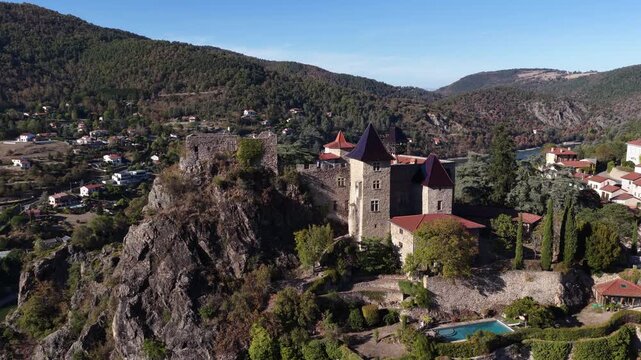 Close aerial of a stone castle perched on a rocky Loire cliff