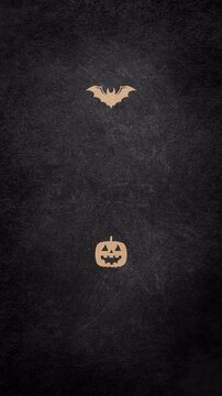 Minimalist Halloween theme featuring a small bat and a carved jack o lantern on a dark textured background.