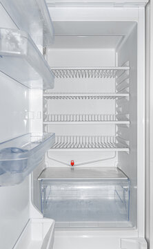 An open empty refrigerator showing clean shelves and door racks inside.