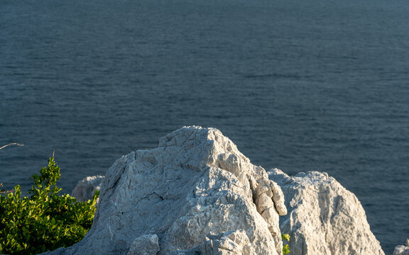 White limestone cliff of Shirasaki Coast facing calm blue sea under soft daylight in Japan