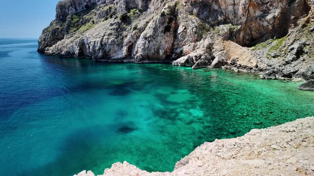 Mali Bok Beach on Cres Island, Croatia. Hidden cove with turquoise Adriatic Sea, dramatic limestone cliffs and crystal water surrounded by unspoiled Mediterranean nature in Cres Island of Croatia