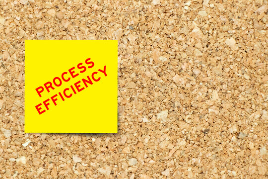 Yellow note paper with word process efficiency on cork board background with copy space