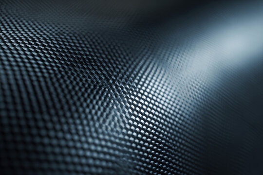 A closeup of a carbon fiber texture with light reflecting off the surface