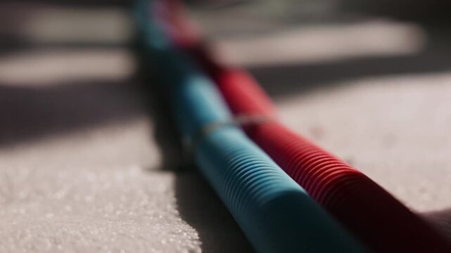 Red and blue corrugated water pipes laid on construction floor
