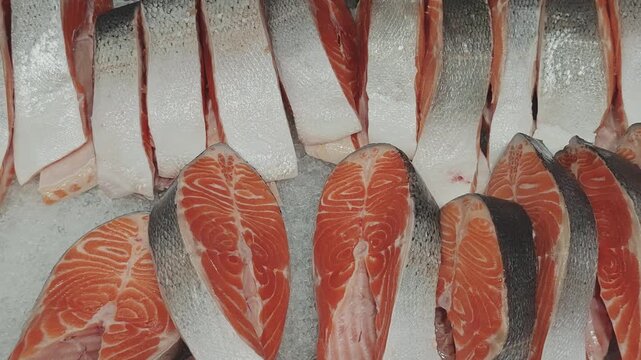 Overhead shot of beautiful raw salmon fillets resting on a bed of ice chips. Displayed at the seafood section of a market, offering a nutritious choice for health conscious individuals