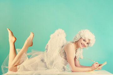 Obraz premium Valentine romance concept with a cupid. Winged Valentine character writing a message. Valentine love concept with an angel. Costumed Valentine cupid with paper and quill.