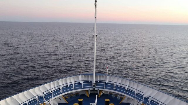 The bow of the cruise ship cuts through the sea, heading towards the mainland