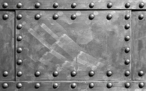 Close-up of a gray metal plate with rivets and scratched surface texture