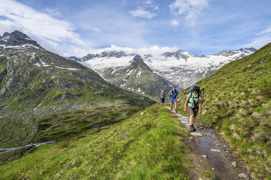 Three mountaineers on a hiking trail in a picturesque mountain landscape, mountain peak with snow and glacier Hornkees and Waxeggkees, summit Hornspitzen and Gro&szlig;er M&ouml;seler, Berliner H&ouml;henweg, Zillertal Alps, Tyrol, Austria