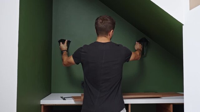 Man checking the position of a shelf before mounting it on the wall