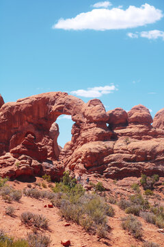 Red rock arch formations under a blue sky in Arches National Park