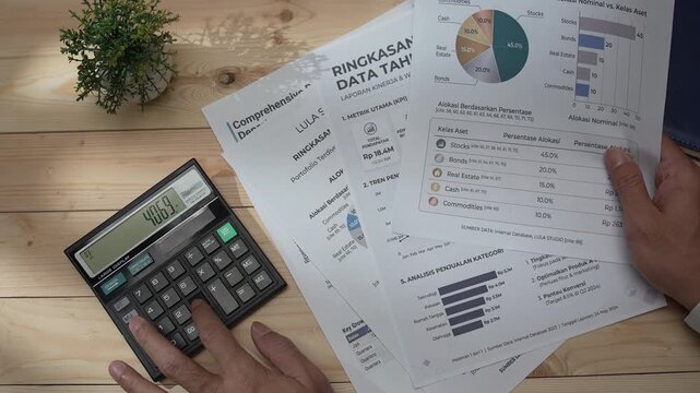 Man using a calculator and reviewing financial reports with investment charts on a desk, showcasing business finance, accounting, investment analysis, financial planning, and money management.