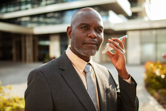 Businessman speaking on smartphone outside office building