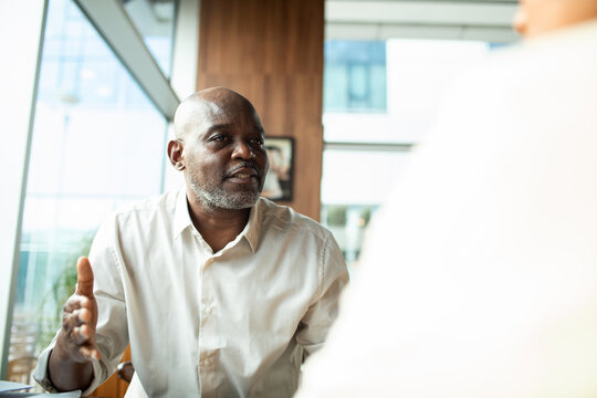 Mature man explaining during one-on-one office meeting