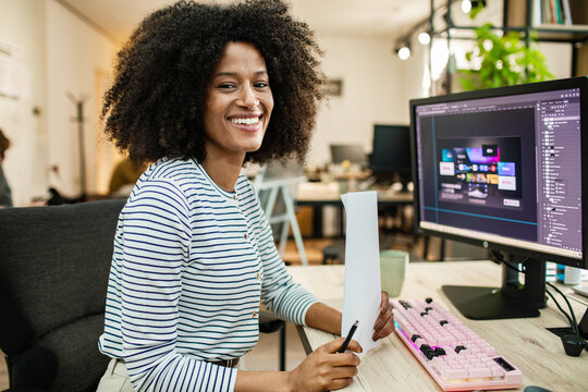 Smiling graphic designer reviewing ui mockup at office desk